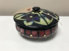 A Moorcroft tubelined Violets pattern powder bowl and cover, diameter 13 cm.