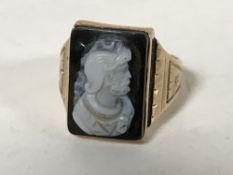A Victorian gold and onyx ring with carved relief decoration