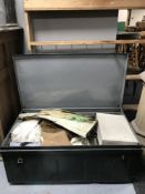 A metal trunk containing a quantity of vintage clothing.