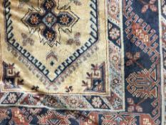 A fringed Persian carpet on golden ground