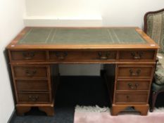 A yew wood twin pedestal desk inset green leather panel top