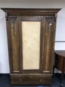 An Edwardian oak single door wardrobe
