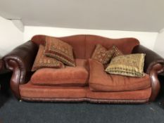 A brown leather and cloth three piece suite
