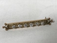 A six stone diamond set yellow gold bar brooch, width 48mm, 5g.