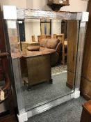 A contemporary all glass bevelled mirror 110 cm x 142 cm