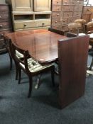 A mahogany Regency style pedestal dining table with three leaves and four chairs