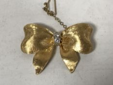 An 18ct gold diamond set bow brooch, 12.