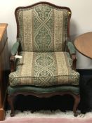 A contemporary salon armchair upholstered in green covering