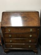 A walnut Queen Anne style bureau fitted four drawers