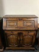 A carved oak writing bureau