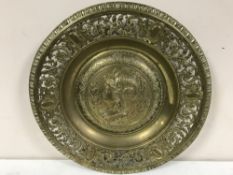 A heavy brass charger decorated with a classical bust
