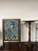 A mahogany pedestal occasional table and a fire screen depicting a peacock