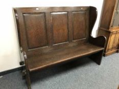 A panelled oak pew,