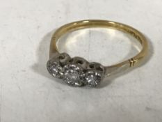 A three stone diamond ring stamped 18ct PLAT