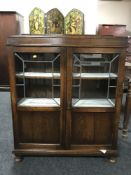 An oak double door bookcase with leaded glass doors