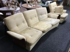A late 20th century teak panelled back three piece suite in a gold fabric