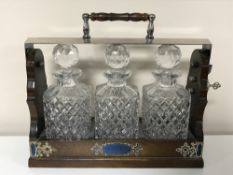 A Victorian style three decanter Tantalus with silver plated mounts