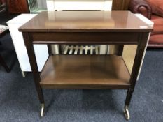 A mahogany two tier trolley fitted a drawer