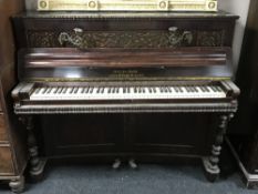 An over-strung piano, in a carved rosewood case, complete with sconces.