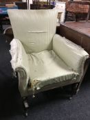 A Regency armchair, on carved legs, upholstered in green striped fabric.