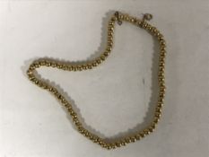 A gold 'ball' necklace on wire core