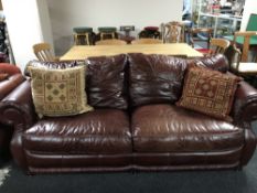 A pair of burgundy leather and cloth settees with scatter cushions