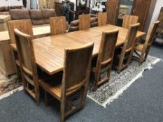 An impressive teak dining table and ten chairs,