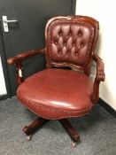 A Victorian style buttoned armchair upholstered in burgundy leather,