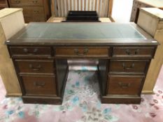 A mahogany twin pedestal desk inset green leather panel top