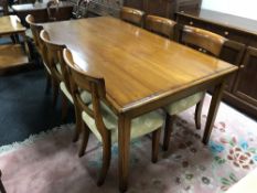 A contemporary walnut dining table and six Victorian style chairs
