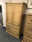 A pine double wardrobe fitted with three drawers,