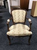 A contemporary continental style armchair upholstered in a beige floral fabric