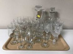 A tray of assorted drinking glasses, claret jug and a decanter, preserve pots,
