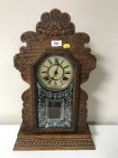 An antique carved American mantel clock with pendulum and key