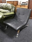 A retro style black leather lounge chair on chrome legs