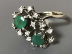 An 18ct white gold diamond and emerald ring,