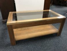 A contemporary walnut two-tier glass topped coffee table