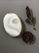 Three antique brooches - two garnet and one agate in gold settings.