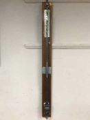 A marine barometer on mahogany bracket