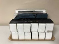 A tray of sixteen model trains on plinths