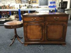 An inlaid mahogany double door sideboard together with a circular drum table