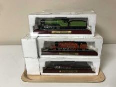 A tray of nineteen plastic model trains on plinths