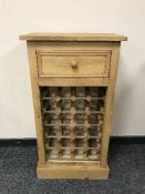 A pine bottle rack fitted with a drawer
