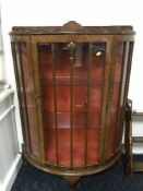 A walnut d-shaped display cabinet and a carved wall shelf