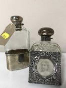A silver lidded scent bottle together with a silver and glass hip flask and a silver embossed photo