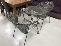 A circular Kettler metal patio table and two armchairs