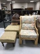 A cane conservatory armchair and two footstools in a gold fabric (one storage)