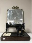 A mahogany Singer sewing machine and a brass mirrored fire screen