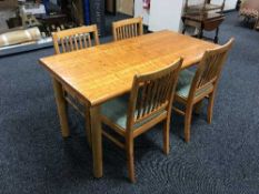 A rectangular kitchen table together with a set of four pine rail back chairs