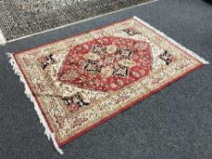 A fringed Persian Heriz carpet on red ground,